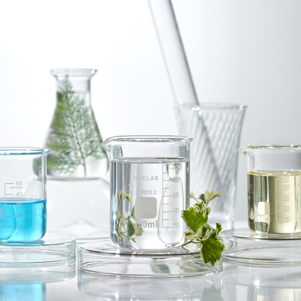 Lab of beakers with gray background and plants in the background